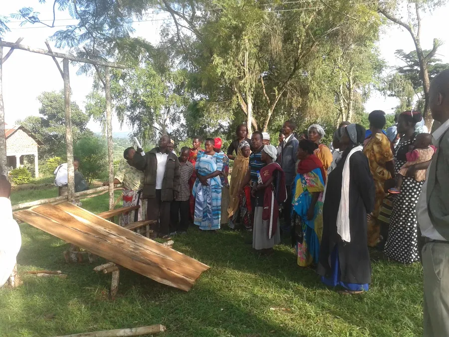 Community members gathering around a demonstration of a locally made device